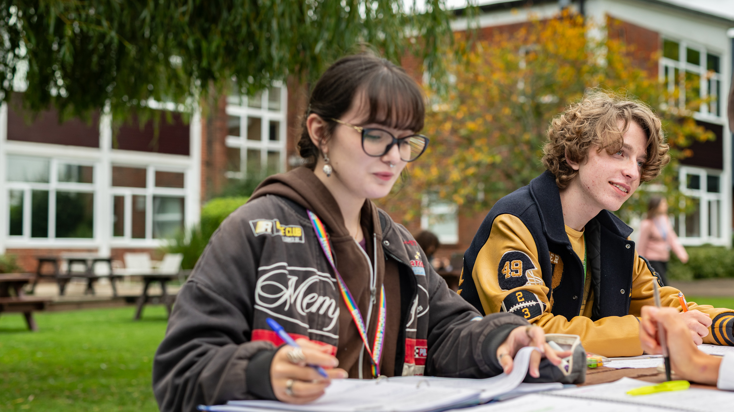 Students studying together at an outdoor picnic table on the Brockenhurst College campus.