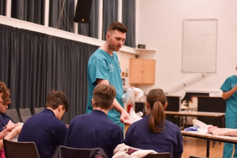 Anatomist from ITEA handing out gloves to school pupils in preparation for the dissection activities