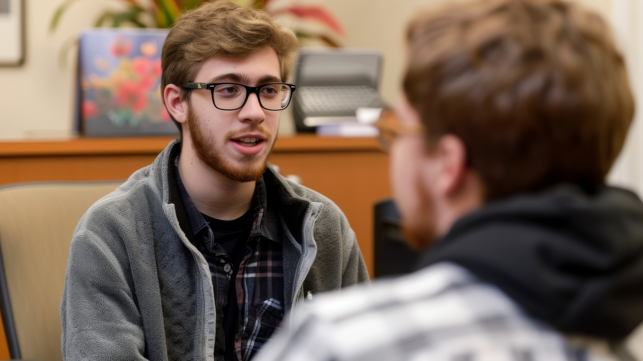 Two students sat across from each other in conversation